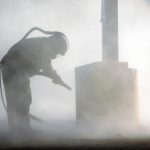 a worker sandblasting