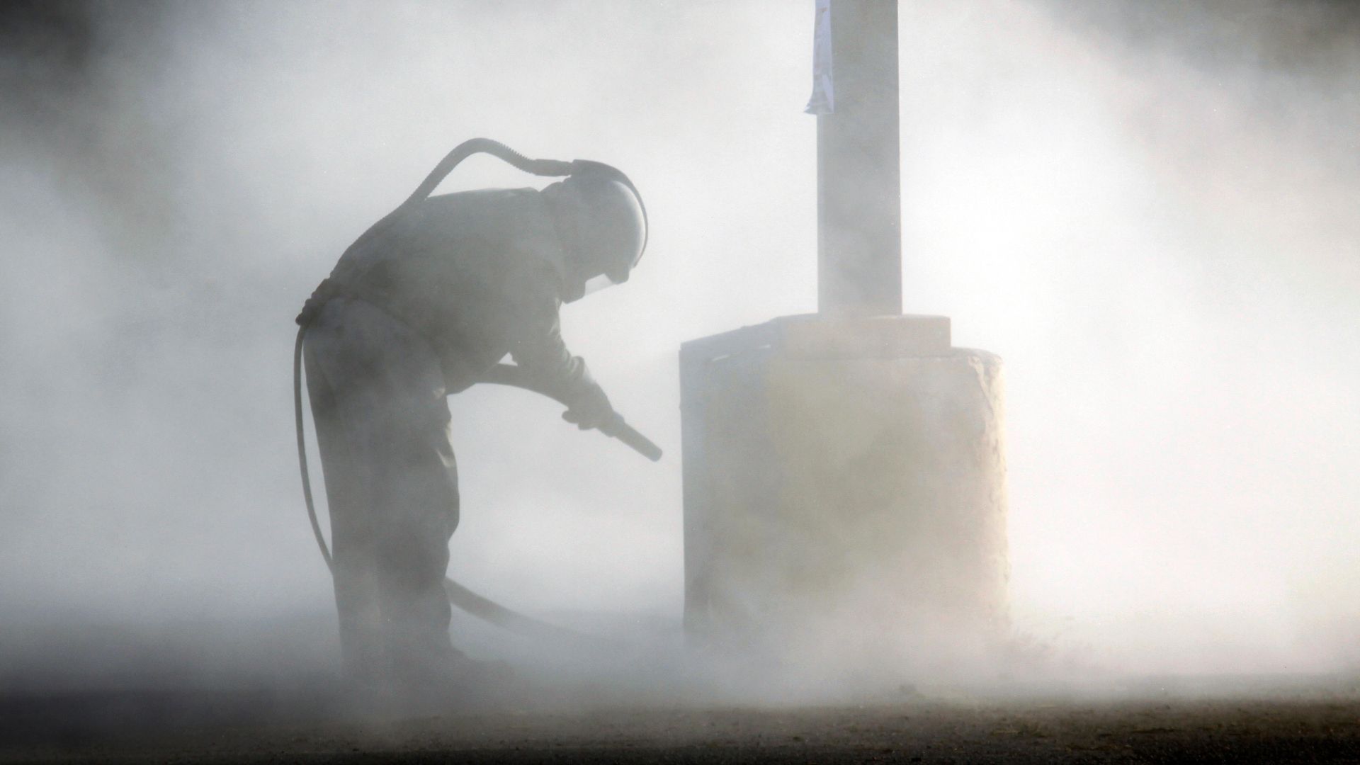 a worker sandblasting